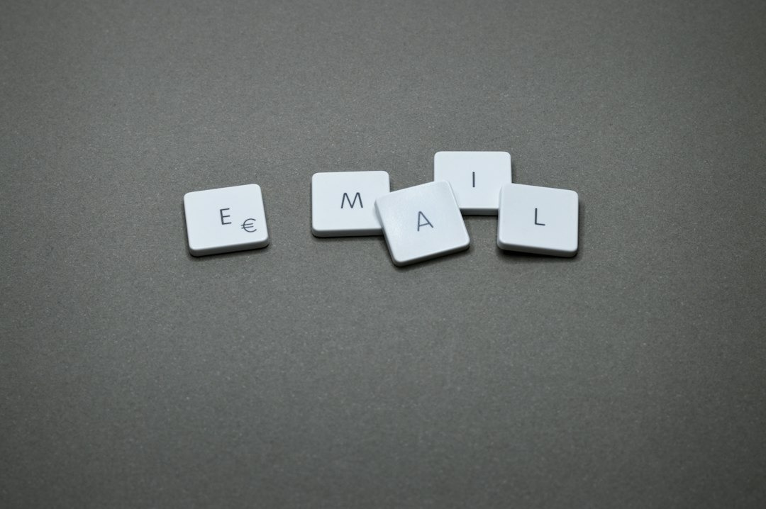 Five letter tiles spell out E-MAIL on a grey surface.